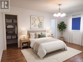 Barrie (Painswick South) apartment for rent - A bedroom with a large bed, a chandelier, and a painting on the wall.