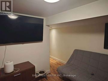 Toronto (Corso Italia-Davenport) duplex for rent - A living room with a grey couch and a flat screen TV mounted on the wall.
