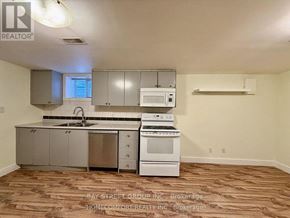Toronto (Corso Italia-Davenport) duplex for rent - A kitchen with white appliances and wooden flooring.