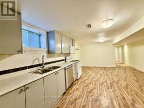 Toronto (Corso Italia-Davenport) duplex for rent - A kitchen with white cabinets and a sink.