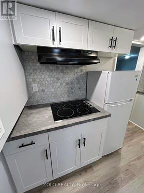 Kitchener apartment for rent - A kitchen with white cabinets and a black stove top.