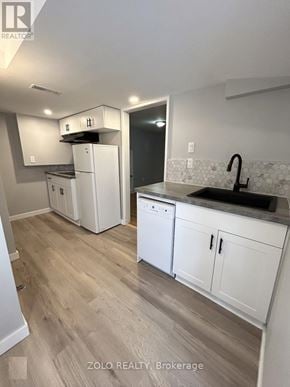 Kitchener apartment for rent - A kitchen with white cabinets and a black sink.
