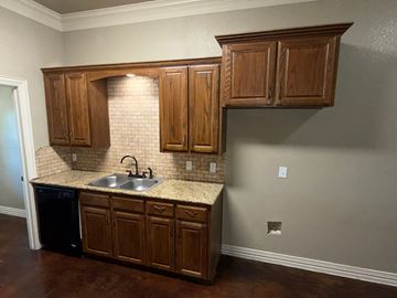 Temple triplex for rent - A kitchen with wooden cabinets and a sink.