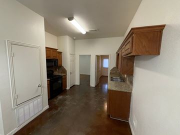 Temple triplex for rent - A kitchen with brown cabinets and a brown floor.