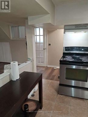 Toronto (Woburn) apartment for rent - A kitchen with a stove and a table with a bottle on it.