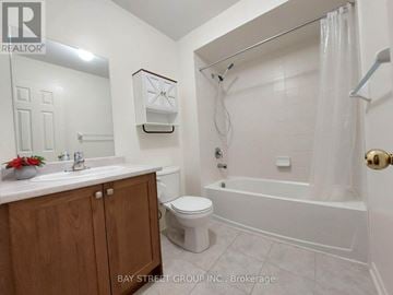 Richmond Hill townhouse for rent - A white bathroom with a toilet, sink, and bathtub.