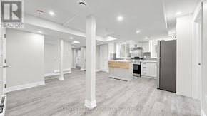 Kitchener apartment for rent - A spacious kitchen with a refrigerator, sink, and cabinets.