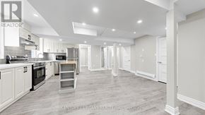 Kitchener apartment for rent - A spacious kitchen with white cabinets and a wooden floor.