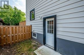 Niagara Falls (Downtown) apartment for rent - A house with a grey siding and a white door is for sale.