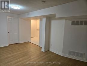 Markham (Middlefield) apartment for rent - A room with white walls and wooden flooring, with a door on the left and a window on the right.