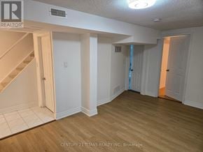 Markham (Middlefield) apartment for rent - A room with wooden floors and white walls, with a staircase on the left side.