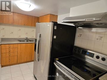 Markham (Middlefield) apartment for rent - A kitchen with a black fridge and stove.