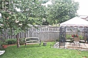 Mississauga (Meadowvale) apartment for rent - A backyard with a white gazebo, a bench, and a table with chairs.
