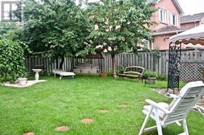 Mississauga (Meadowvale) apartment for rent - A backyard with a white lawn chair and a white umbrella.