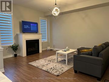 Ajax (Northwest Ajax) townhouse for rent - A living room with a fireplace and a television on top of it.