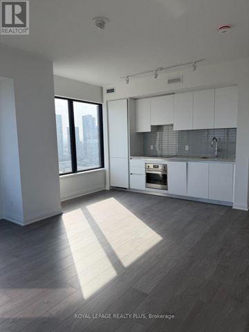 Mississauga (City Centre) condo for rent - A spacious kitchen with white cabinets and a view of the city.