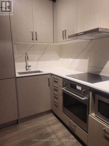 Vaughan (Vaughan Corporate Centre) condo for rent - A kitchen with wooden cabinets and stainless steel appliances.