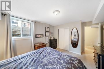 Barrie (Georgian Drive) townhouse for rent - A bedroom with a large bed and a mirror on the wall.