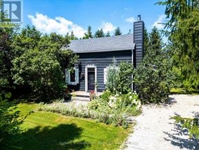 Blue Mountains apartment for rent - A small house with a grey roof and a chimney is surrounded by greenery.