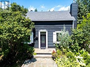 Blue Mountains apartment for rent - A house with a grey exterior and a black door surrounded by greenery.