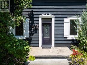 Blue Mountains apartment for rent - A grey house with a dark brown door and a small window on the side.