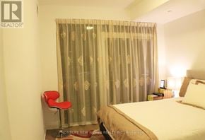 Toronto (Mimico) condo for rent - A bedroom with a bed, chair, and curtains.