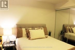 Toronto (Mimico) condo for rent - A bedroom with a bed, nightstand, and lamp.
