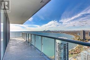 Toronto (Mimico) condo for rent - A balcony overlooks a body of water with buildings in the distance.
