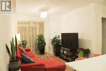 Toronto (Mimico) condo for rent - A living room with a red couch and a flat screen TV.