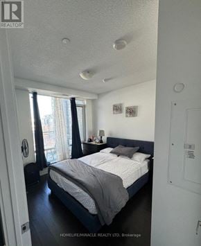 Mississauga (Central Erin Mills) condo for rent - A bedroom with a bed, nightstand, and window with curtains.