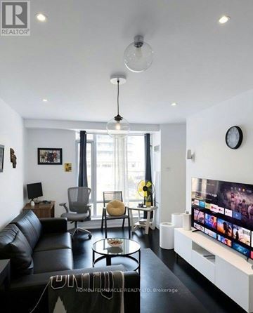 Mississauga (Central Erin Mills) condo for rent - A modern living room with a black leather couch and a flat screen TV.