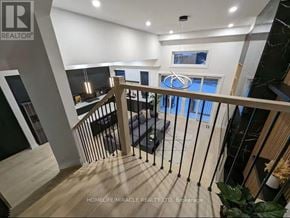 Toronto (Mimico) apartment for rent - A modern interior space with a staircase leading to a balcony.