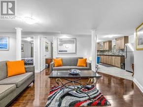 Brampton (Credit Valley) apartment for rent - A living room with a grey couch and a rug with a black, white and red design.