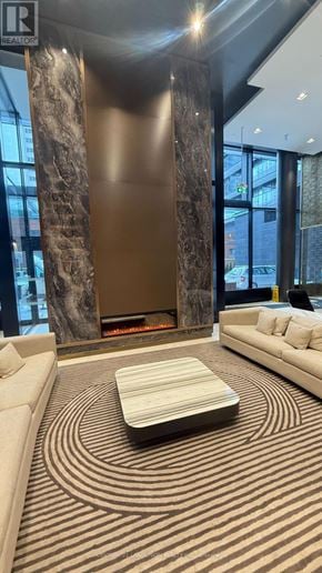 Toronto (Mount Pleasant West) condo for rent - A large, modern room with a marble column and a wooden coffee table.