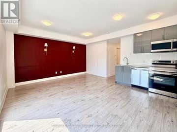 Niagara Falls (Arad/Fallsview) condo for rent - A spacious kitchen with a red wall and stainless steel appliances.