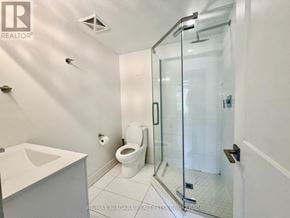 Niagara Falls (Arad/Fallsview) condo for rent - A white bathroom with a glass shower door and a toilet.