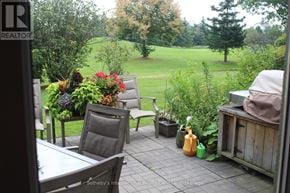 Blue Mountains townhouse for rent - A patio with a table and chairs overlooking a green field.