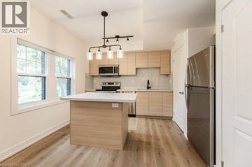 Kitchener apartment for rent - A modern kitchen with wooden cabinets and a stainless steel refrigerator.