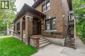 Kitchener apartment for rent - A house with a brick facade and a staircase leading to the entrance.