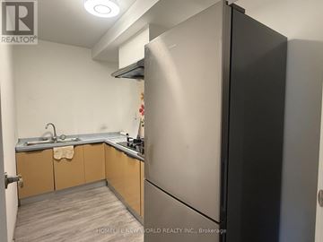 Markham (Bullock) apartment for rent - A kitchen with a black refrigerator and wooden cabinets.