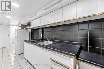 Toronto (Mount Pleasant West) apartment for rent - A kitchen with white cabinets and black tiles on the wall.