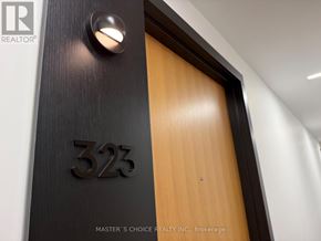 Toronto (South Riverdale) condo for rent - A door with the number 323 on it is part of a wood and metal door.