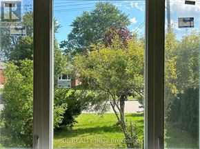 Toronto (Wexford-Maryvale) apartment for rent - A tree with red flowers is seen through a window.