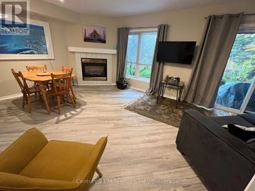 Collingwood condo for rent - A living room with a fireplace and a television.