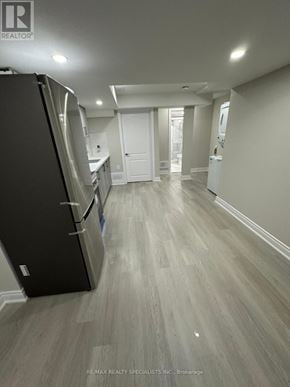 Brampton (Northwest Sandalwood Parkway) apartment for rent - A black refrigerator is in the corner of a room with wood flooring.