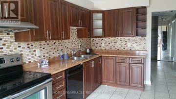 Brampton (Heart Lake West) apartment for rent - A kitchen with wooden cabinets and a tiled backsplash.