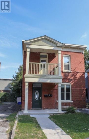 Ottawa fourplex for rent - A two-story brick house with a balcony on the second floor.