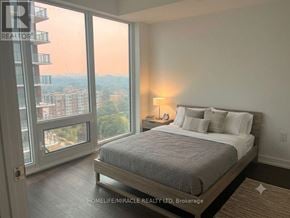 Toronto (Humber Heights) condo for rent - A bedroom with a large bed and a view of the city.