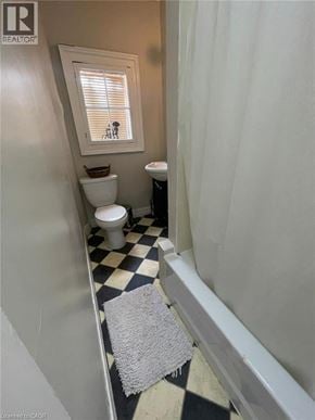 London apartment for rent - A small bathroom with a toilet, sink, and window.