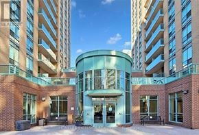 Toronto (Willowdale East) condo for rent - A modern building with a glass entrance and brick walls.
